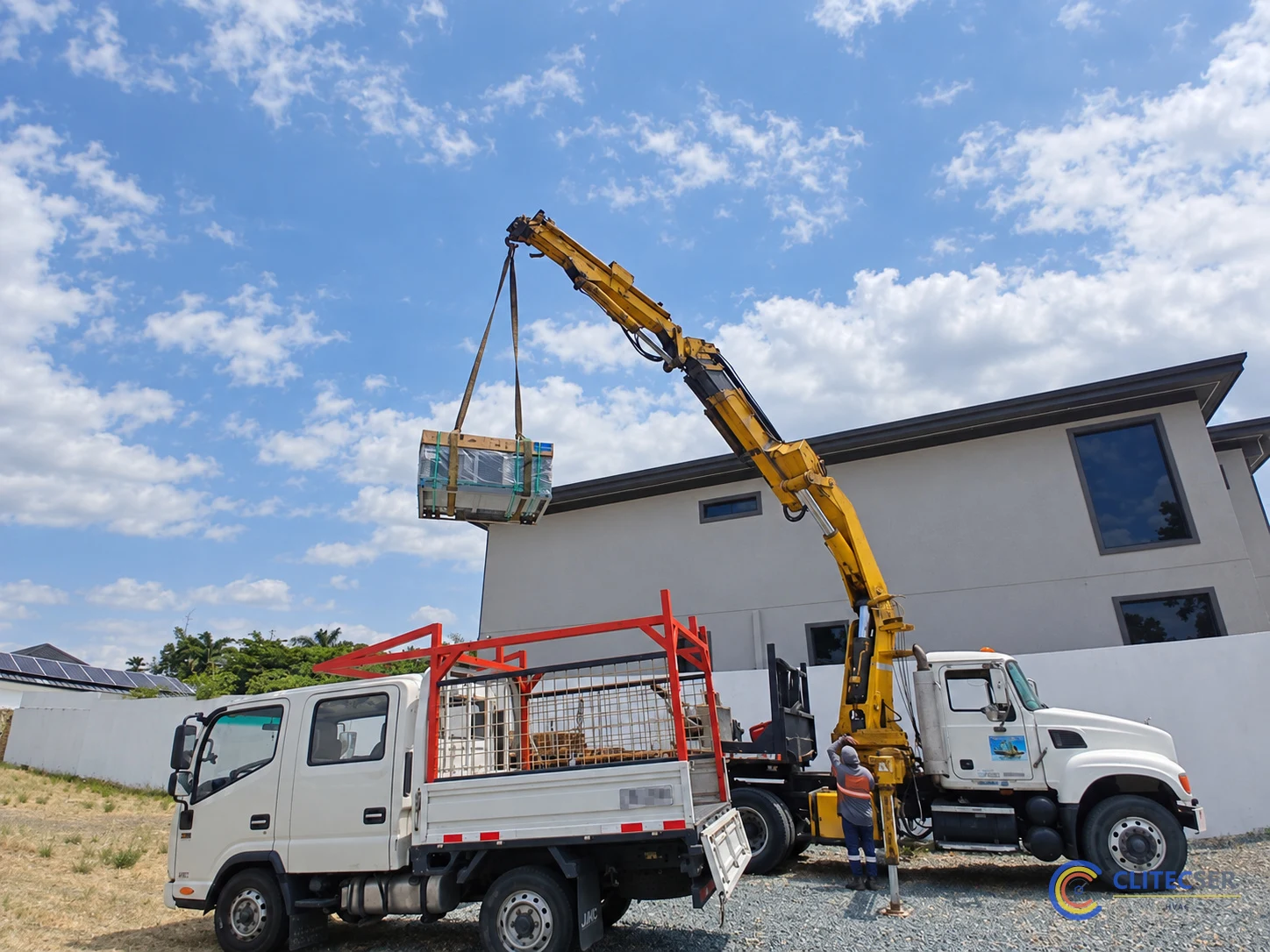 Izaje del equipo paquete HVAC con grúa frente a la vivienda de Samborondón.