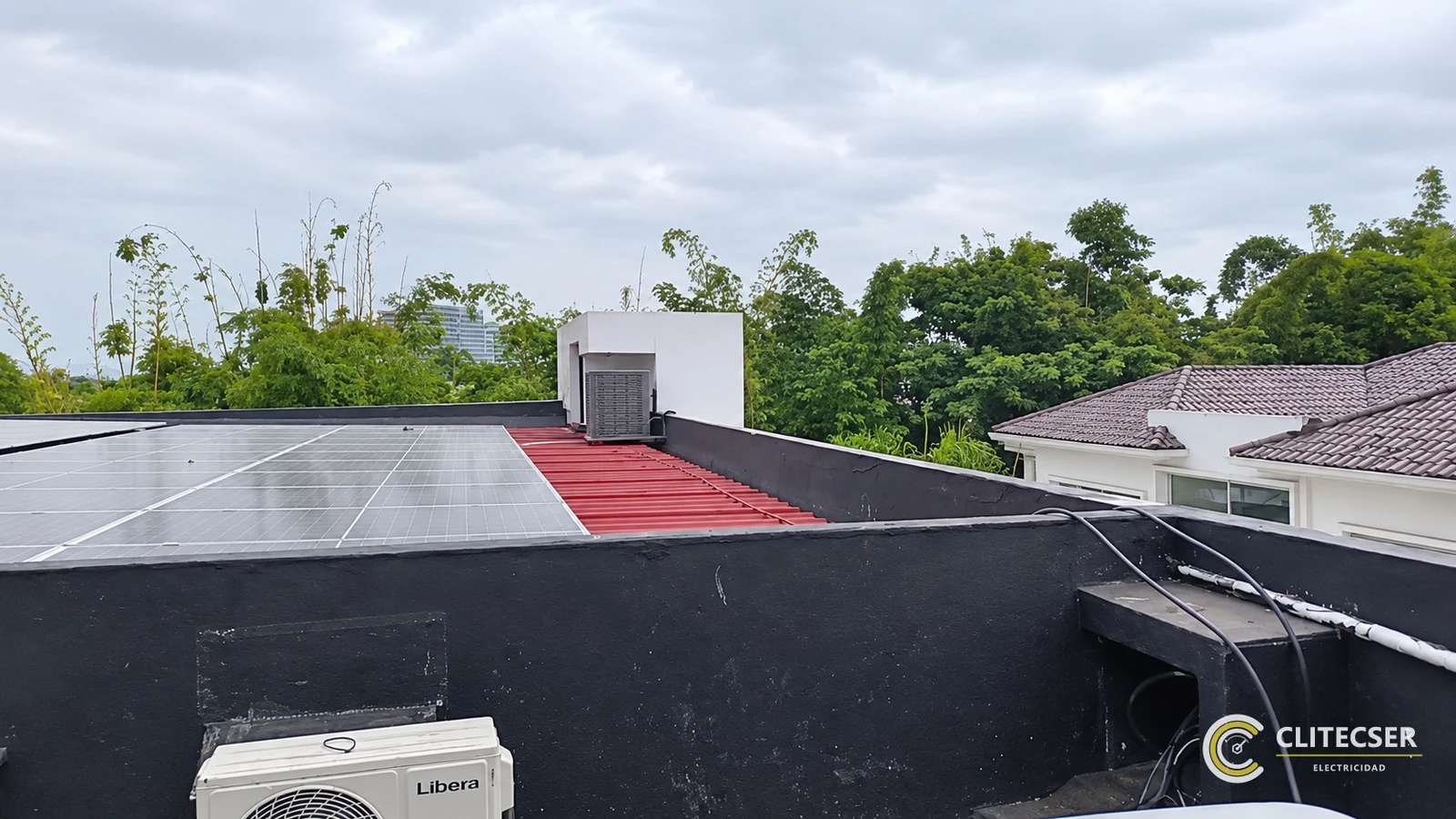 Paneles solares instalados sobre la cubierta metálica roja de la vivienda.